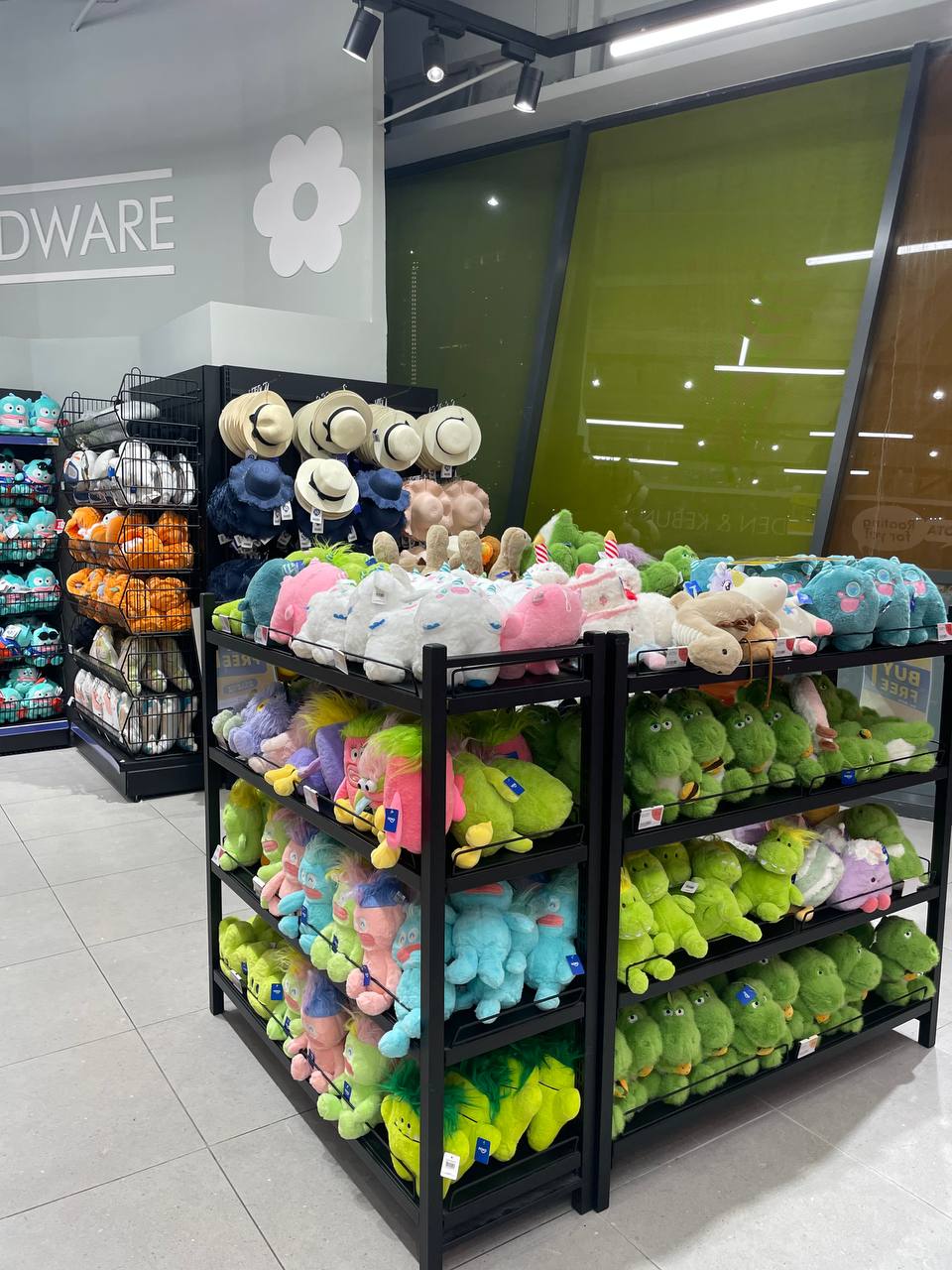 Стеллажи с разноцветными мягкими игрушками и шляпами в магазине.