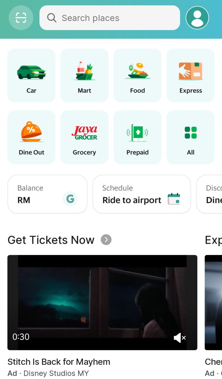 The image shows a screenshot of the Grab app on a mobile device, with a search bar at the top and various icons representing different services offered by the app. The icons are arranged in a grid pattern and include images of a car, a mart, food, an express delivery service, dine-out options, a grocery store